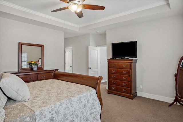 bedroom featuring a tray ceiling, light carpet, crown molding, and baseboards