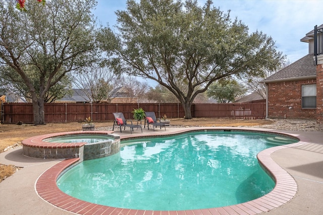 view of swimming pool with a patio area, a pool with connected hot tub, and a fenced backyard