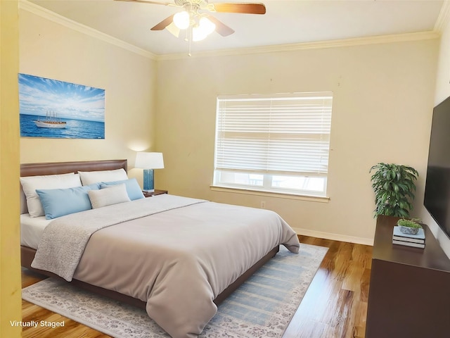 bedroom featuring ceiling fan, crown molding, baseboards, and wood finished floors