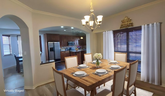 dining space with arched walkways, a chandelier, baseboards, dark wood-style floors, and crown molding