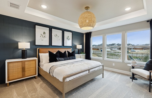 bedroom featuring visible vents, a tray ceiling, ornamental molding, and light colored carpet