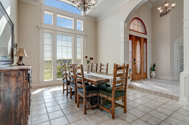 dining area with arched walkways, ornamental molding, an inviting chandelier, and light tile patterned floors