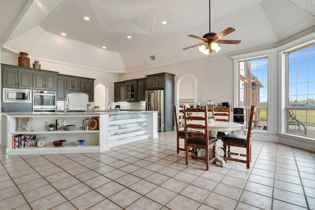 dining area with lofted ceiling, light tile patterned floors, wood ceiling, arched walkways, and ceiling fan