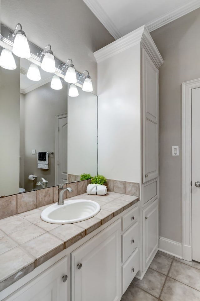 bathroom with toilet, tile patterned floors, vanity, and crown molding