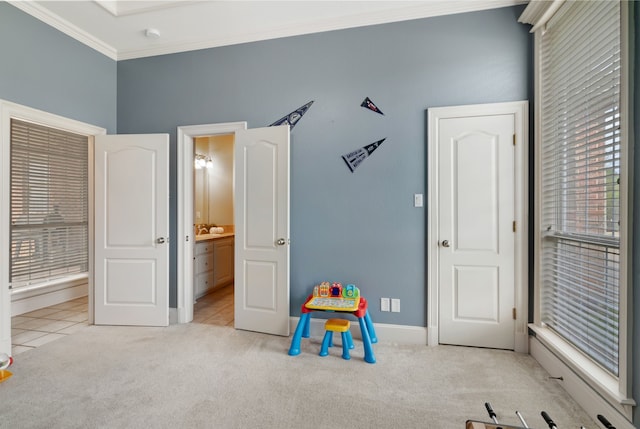 recreation room featuring baseboards, ornamental molding, carpet, and plenty of natural light