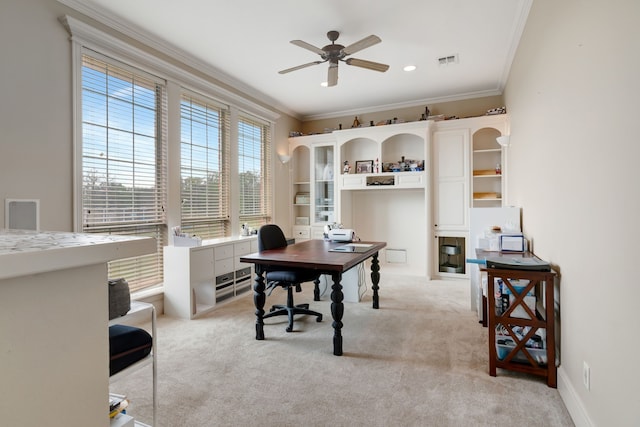 home office with ornamental molding, baseboards, ceiling fan, visible vents, and light carpet