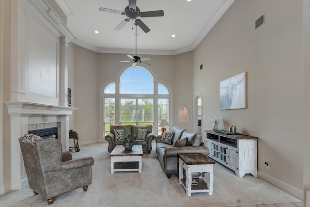 living room featuring visible vents, crown molding, baseboards, a ceiling fan, and light carpet