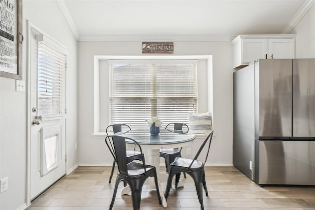 dining room featuring ornamental molding, wood tiled floor, and baseboards