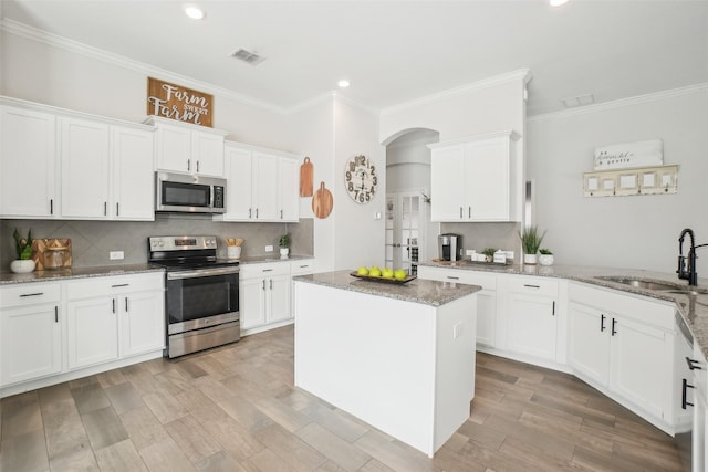 kitchen featuring stainless steel appliances, white cabinets, visible vents, and a sink