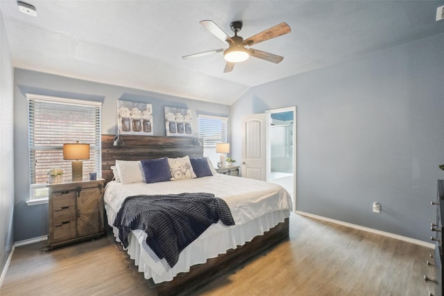 bedroom with lofted ceiling, wood finished floors, visible vents, and baseboards