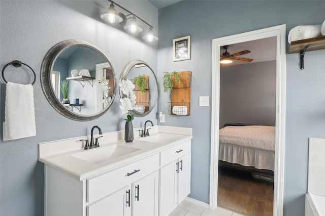 bathroom featuring double vanity, ensuite bath, a ceiling fan, and a sink