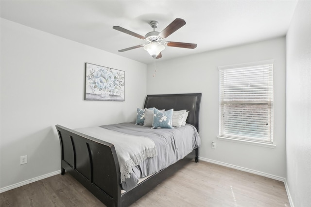 bedroom featuring ceiling fan, baseboards, and wood finished floors