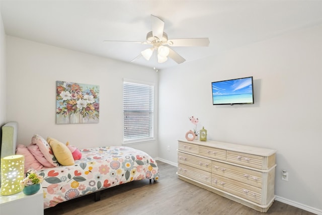 bedroom featuring ceiling fan, baseboards, and wood finished floors