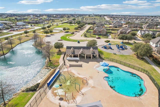 view of pool with a residential view, a water view, and fence