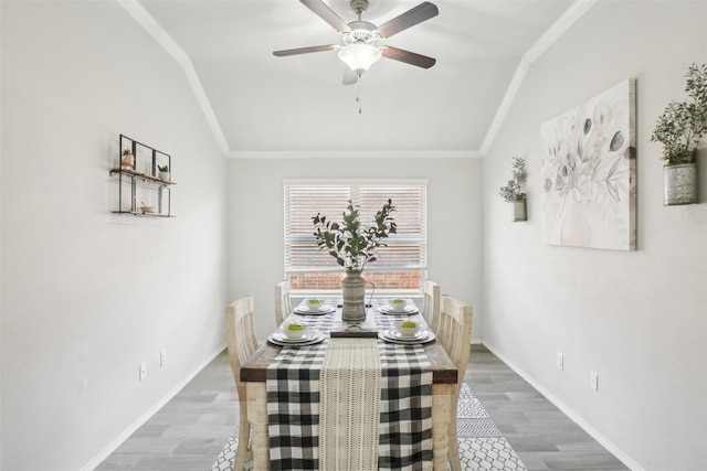 dining room featuring baseboards, a ceiling fan, lofted ceiling, ornamental molding, and wood finished floors