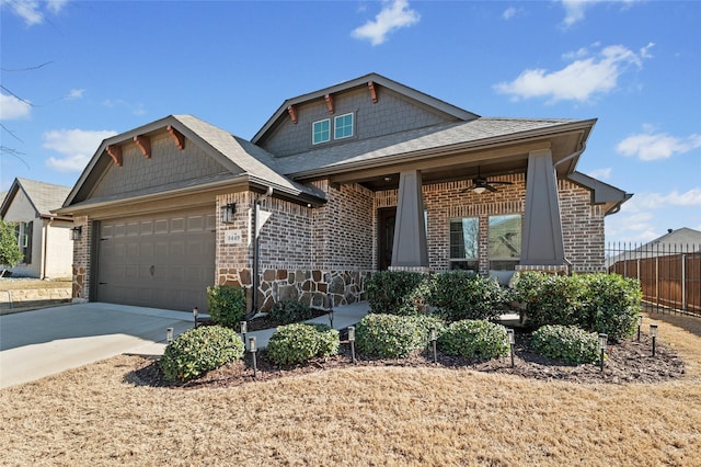 craftsman inspired home with an attached garage, brick siding, fence, a ceiling fan, and driveway