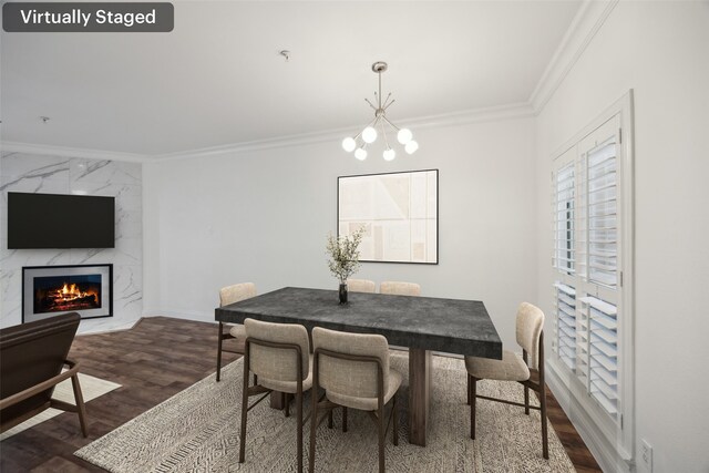 dining room with baseboards, ornamental molding, dark wood-style flooring, a fireplace, and a notable chandelier