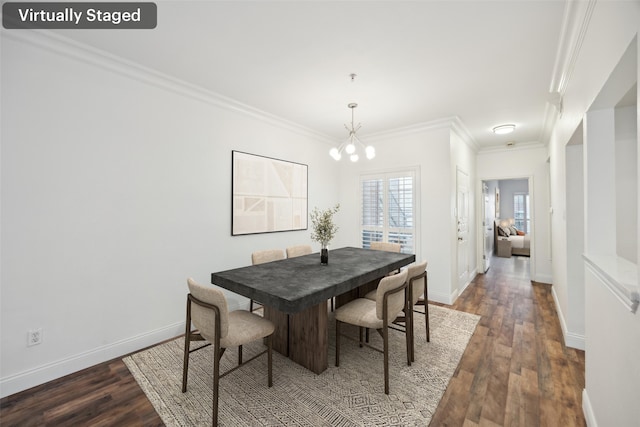 dining space with baseboards, ornamental molding, wood finished floors, and a notable chandelier