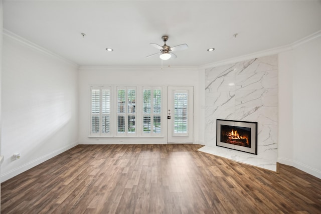 unfurnished living room with a fireplace, crown molding, and wood finished floors