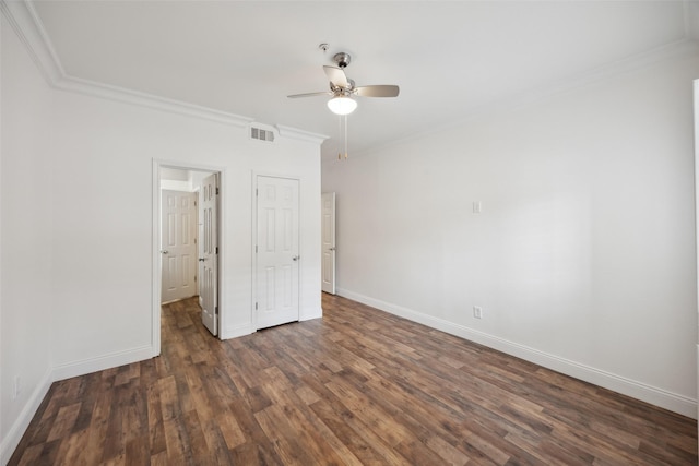 unfurnished bedroom featuring dark wood-style flooring, visible vents, crown molding, and baseboards