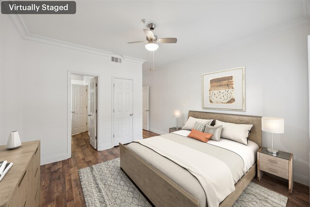 bedroom featuring dark wood-style floors, baseboards, visible vents, and crown molding