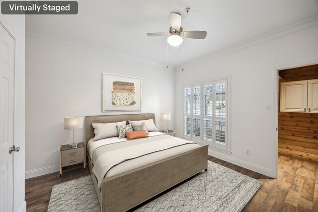 bedroom with ornamental molding, baseboards, and wood finished floors