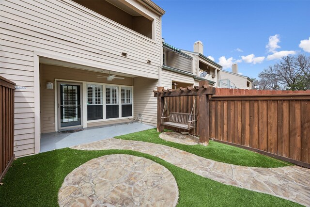 rear view of property with a patio area, fence, and a ceiling fan