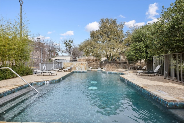 community pool featuring fence and a patio