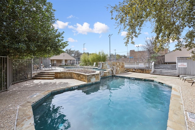 community pool featuring a patio area and fence