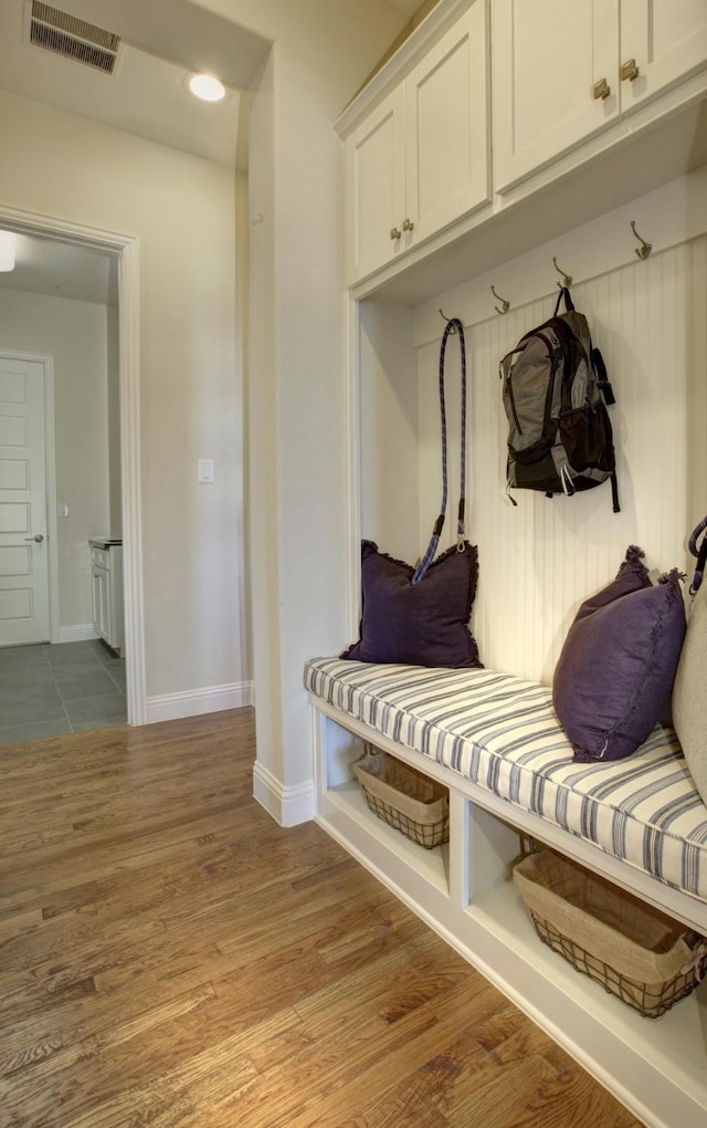 mudroom with wood finished floors, visible vents, and baseboards