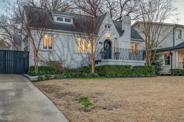 view of front facade with a shingled roof and a front lawn