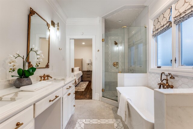 ensuite bathroom with connected bathroom, vanity, a soaking tub, a stall shower, and crown molding