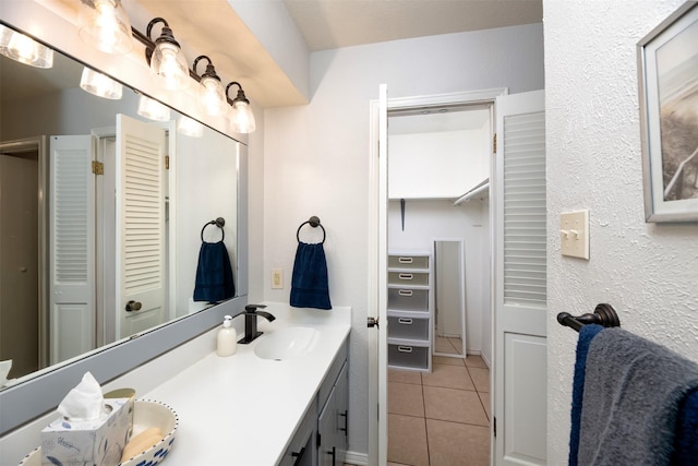 full bath featuring double vanity, a closet, tile patterned flooring, and a sink