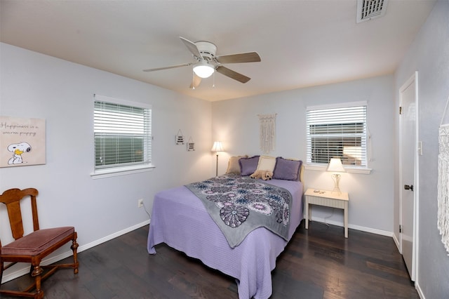 bedroom with baseboards, visible vents, and wood finished floors