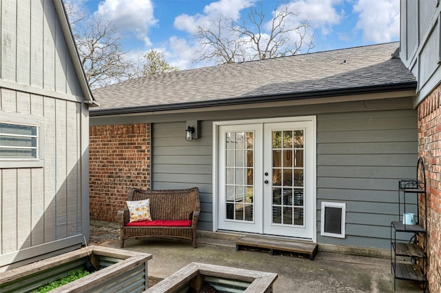 exterior space featuring a patio, french doors, roof with shingles, and brick siding