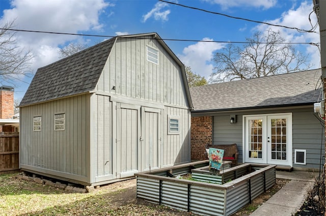 view of outbuilding featuring an outbuilding, french doors, and fence