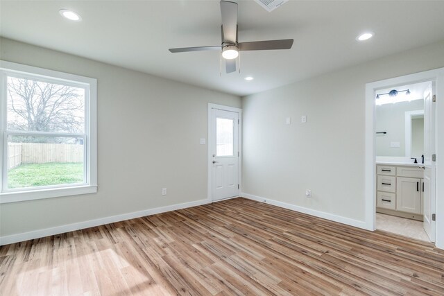 unfurnished bedroom featuring multiple windows, light wood-style flooring, and recessed lighting