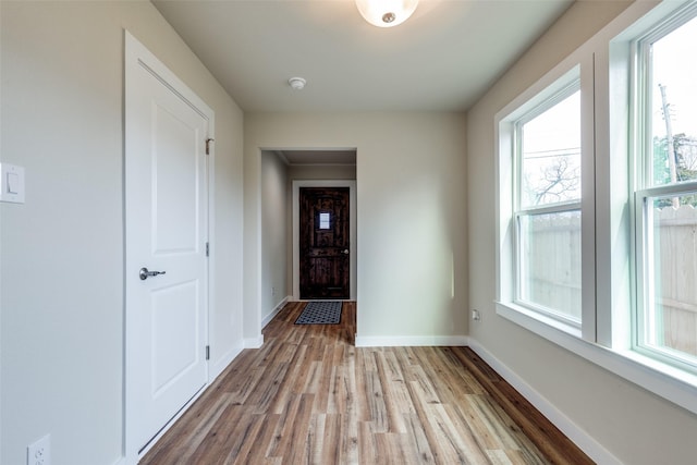 entryway with light wood-type flooring and baseboards