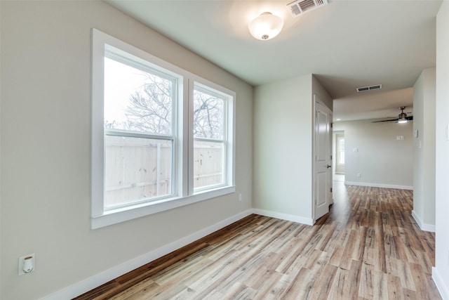 spare room featuring plenty of natural light, visible vents, and baseboards