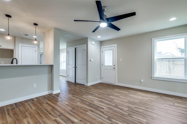 unfurnished living room with recessed lighting, visible vents, light wood-style flooring, a ceiling fan, and baseboards