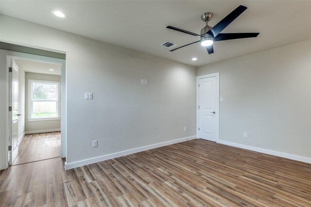 empty room featuring visible vents, ceiling fan, baseboards, and wood finished floors