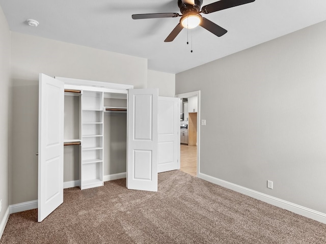 unfurnished bedroom with carpet floors, a ceiling fan, baseboards, and a closet