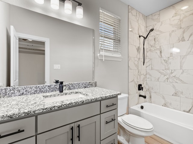 bathroom featuring toilet, bathing tub / shower combination, wood finished floors, and vanity