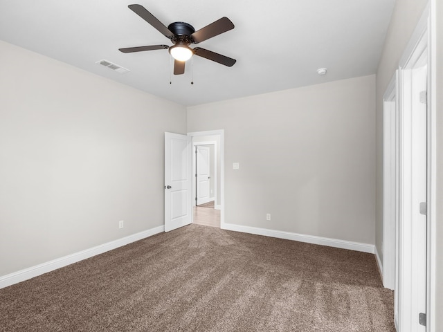 carpeted spare room with a ceiling fan, visible vents, and baseboards