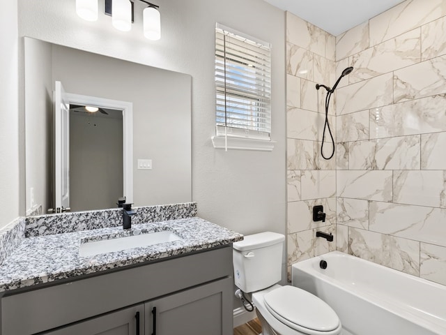 bathroom featuring toilet, a textured wall, vanity, and bathing tub / shower combination