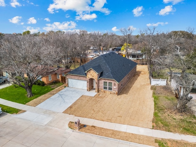 view of front of house featuring a garage, fence, concrete driveway, roof with shingles, and a front lawn