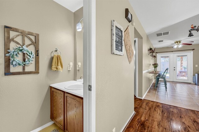 bathroom featuring baseboards, visible vents, french doors, wood finished floors, and vanity