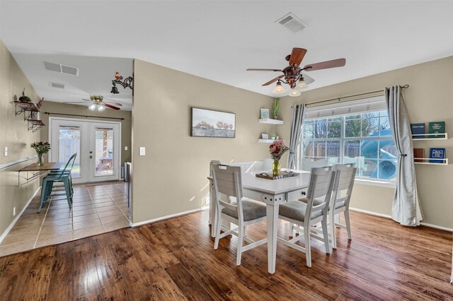 dining space featuring a wealth of natural light, french doors, visible vents, and wood finished floors