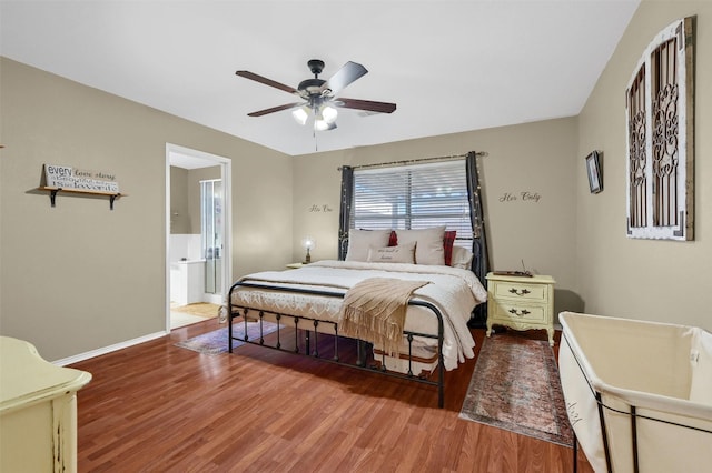 bedroom with a ceiling fan, ensuite bath, baseboards, and wood finished floors