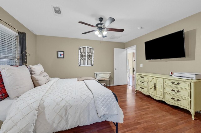 bedroom featuring light wood-style floors, visible vents, and a ceiling fan